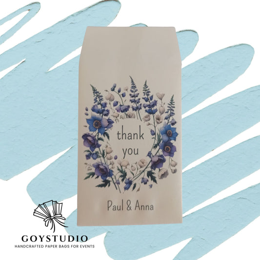 sacchetto in carta avorio con decoro floreale nei colori indaco azzurro e violetto con testo Thank you e soitto Paul e Anna